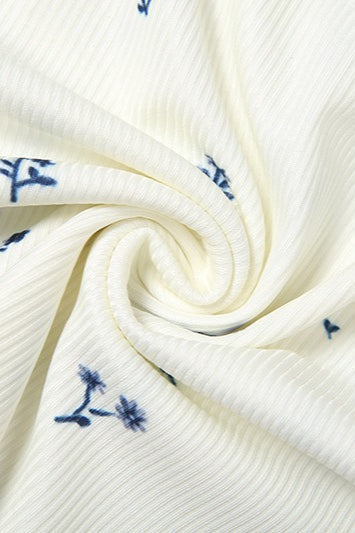 Rosalie White close-up of the swirled rib-knit fabric with small blue floral print.