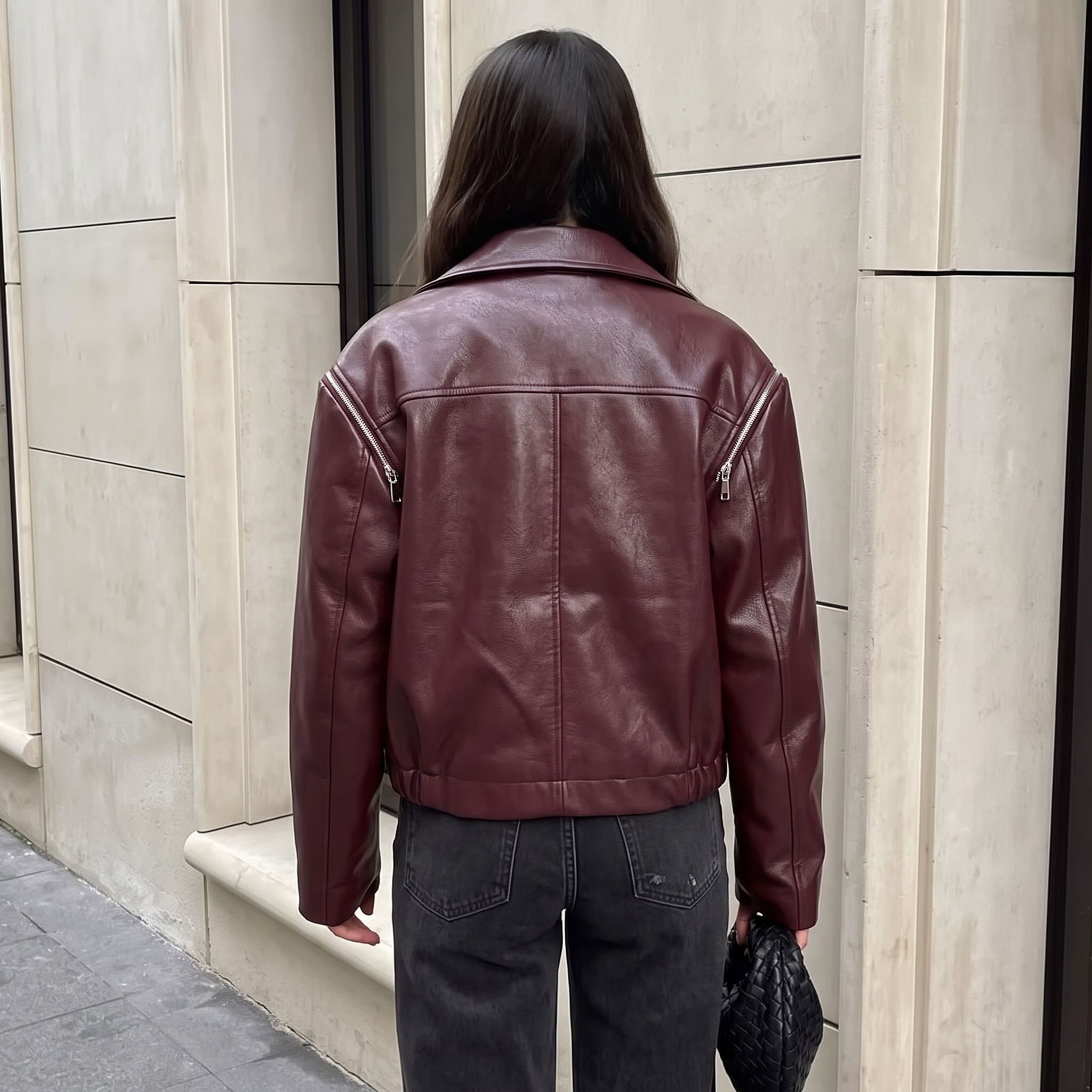Back view of the Rosalind Jacket Faux-Leather Cropped in dark brown, highlighting the clean back design, structured seams, long sleeves, and relaxed cropped silhouette. Designed by Bella Hudson.