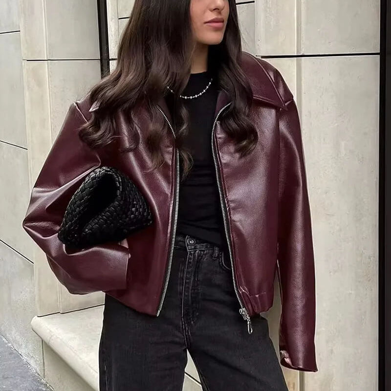 Front view of the Rosalind Jacket Faux-Leather Cropped in dark brown, featuring a collared neckline, zip-front closure, long sleeves, and a relaxed cropped silhouette. Designed by Bella Hudson.