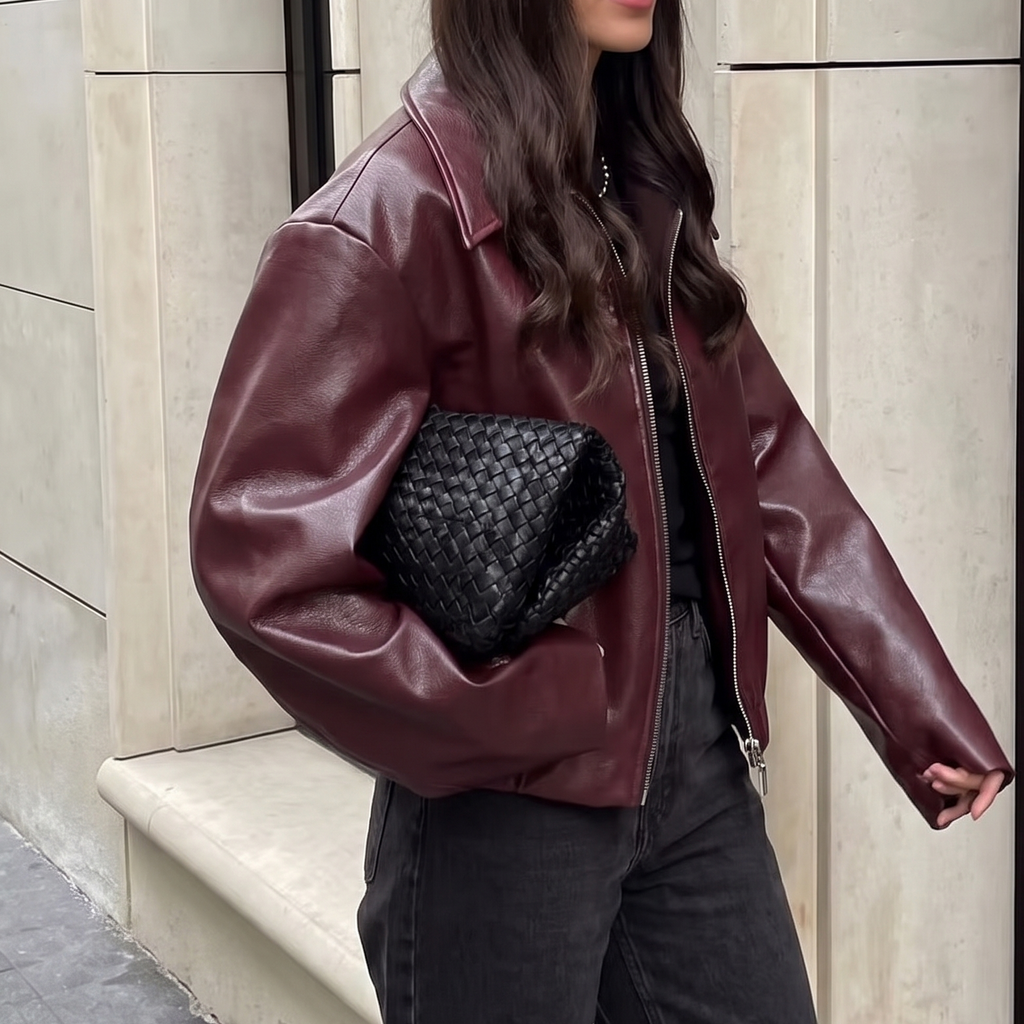 Side view of the Rosalind Jacket Faux-Leather Cropped in dark brown, showcasing the relaxed cropped fit, collared neckline, long sleeves, and smooth faux-leather finish. Designed by Bella Hudson.
