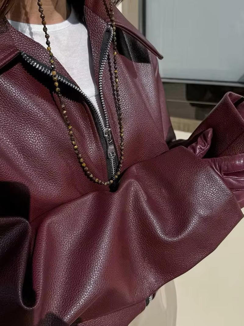 Sleeve detail view of the Rosalind Jacket Faux-Leather Cropped in dark brown, showcasing the long sleeve construction, relaxed fit, stitching details, and smooth faux-leather finish. Designed by Bella Hudson.