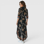 Back view of the Rosamund Shirt Dress Printed Long-Sleeve Button-Front in black, highlighting the all-over chain print, relaxed fit, and maxi-length silhouette. Designed by Bella Hudson.