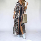 Front view of the Rosamund Shirt Dress Printed Long-Sleeve Button-Front in brown, featuring a collared neckline, button-front closure, printed fabric, side slit, and a flowing maxi silhouette. Designed by Bella Hudson.
