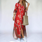 Front view of the Rosamund Shirt Dress Printed Long-Sleeve Button-Front in red, featuring a collared neckline, button-front closure, printed fabric, side slit, and a flowing maxi silhouette. Designed by Bella Hudson.