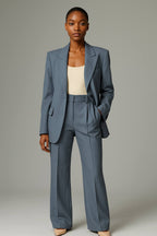 Rowena Blue blazer and pleated wide-leg pants set with a hand in pocket.