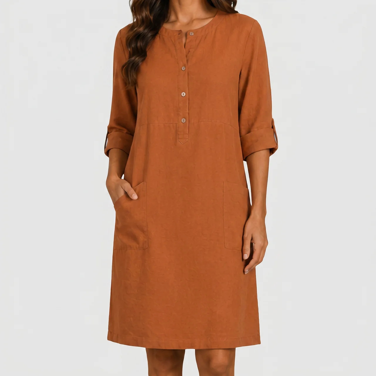 Front view of rust linen midi dress with rolled sleeves and side pockets by BELLA HUDSON