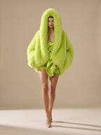 Sabrina Green faux-fur hooded jacket featuring a cropped silhouette, oversized hood, voluminous long sleeves, and plush textured finish