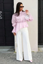 Sabrina Pink ruffle-hem blouse with gathered waist and lace-trim cuffs styled with white wide-leg pants.