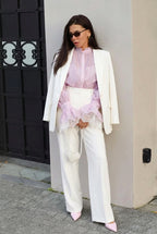 Sabrina Pink blouse with lace-trim cuffs layered under a white blazer with white wide-leg pants.