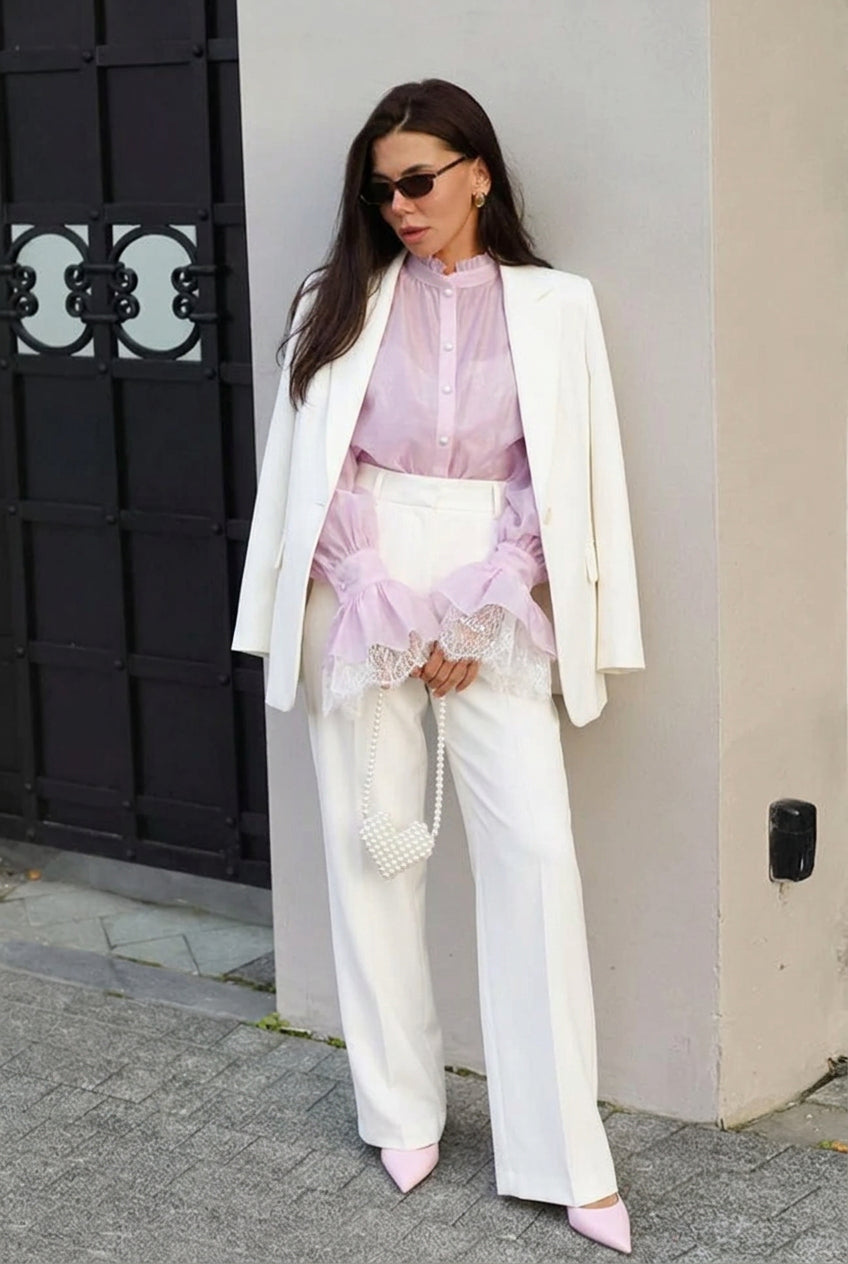 Sabrina Pink blouse with lace-trim cuffs layered under a white blazer with white wide-leg pants.