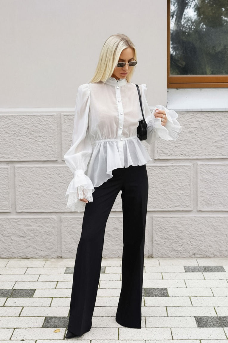 Sabrina White sheer ruffle-hem blouse with lace-trim cuffs styled with black wide-leg pants.