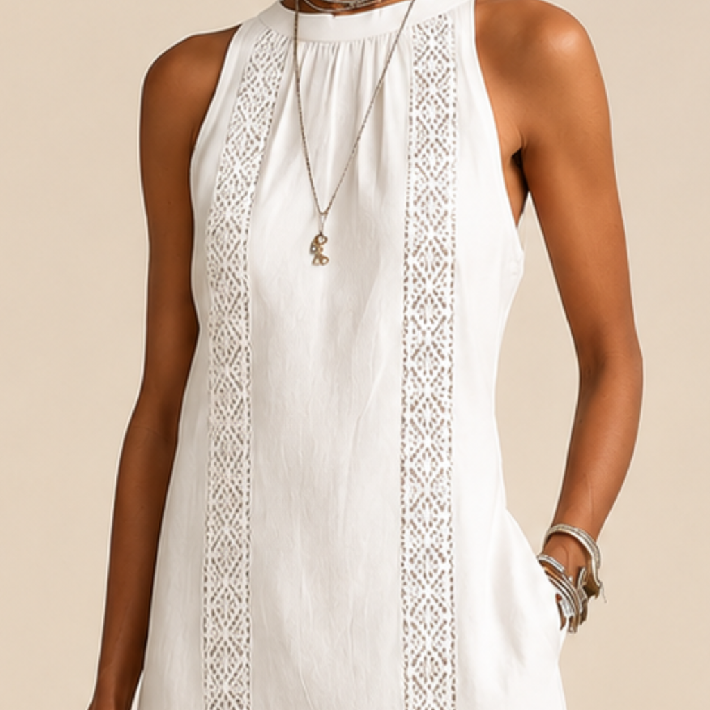 Close-up detail of the Saffia Lightweight Cotton-Linen Sleeveless Midi Dress in white highlighting the high neckline, decorative lace panel detailing, lightweight cotton-linen texture, and relaxed construction. Designed by Bella Hudson.