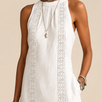Close-up detail of the Saffia Lightweight Cotton-Linen Sleeveless Midi Dress in white highlighting the high neckline, decorative lace panel detailing, lightweight cotton-linen texture, and relaxed construction. Designed by Bella Hudson.