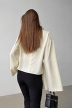 Selene Apricot blouse from the back showing the center seam and wide flared sleeves.