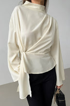 Selene Apricot blouse close-up of the mock neckline, asymmetric drape and gathered waist.