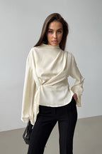 Selene Apricot blouse shown from the front with a crossover drape, gathered waist and long flared sleeves.
