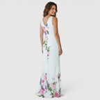 Back view of the Seraphine Maxi Dress Floral-Print Bodycon V-Neck in white, highlighting the fitted silhouette, sleeveless design, floral print, and graceful fishtail maxi skirt. Designed by Bella Hudson.