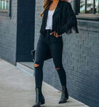 Sienna Black faux-suede moto jacket featuring a cropped silhouette, long fringe detailing, notched lapels, and fitted long sleeves