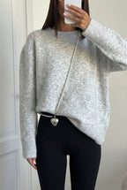 Sienna Gray fuzzy crew-neck sweater styled with black leggings and a pearl-chain bag.