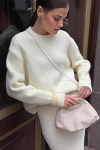 Sienna White fuzzy crew-neck sweater styled with a matching ribbed skirt and a pearl-strap bag.