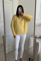 Sienna Yellow oversized sweater worn with white leggings in a mirror selfie.