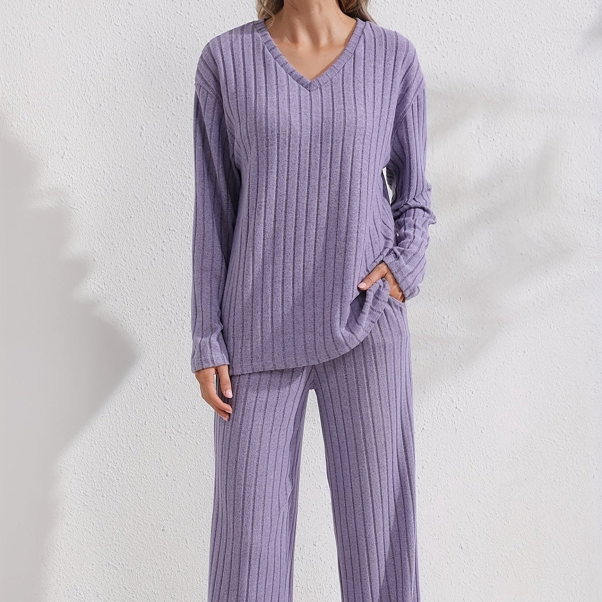 Sloane Purple ribbed two-piece lounge set shown from the front with a long-sleeve V-neck top, vertical ribbed texture, and wide-leg pants