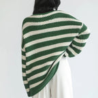 Back view of the Solange Sweater Chunky-Knit Striped in green, featuring green and white horizontal stripes, long sleeves, chunky knit texture, and an oversized relaxed silhouette. Designed by Bella Hudson.