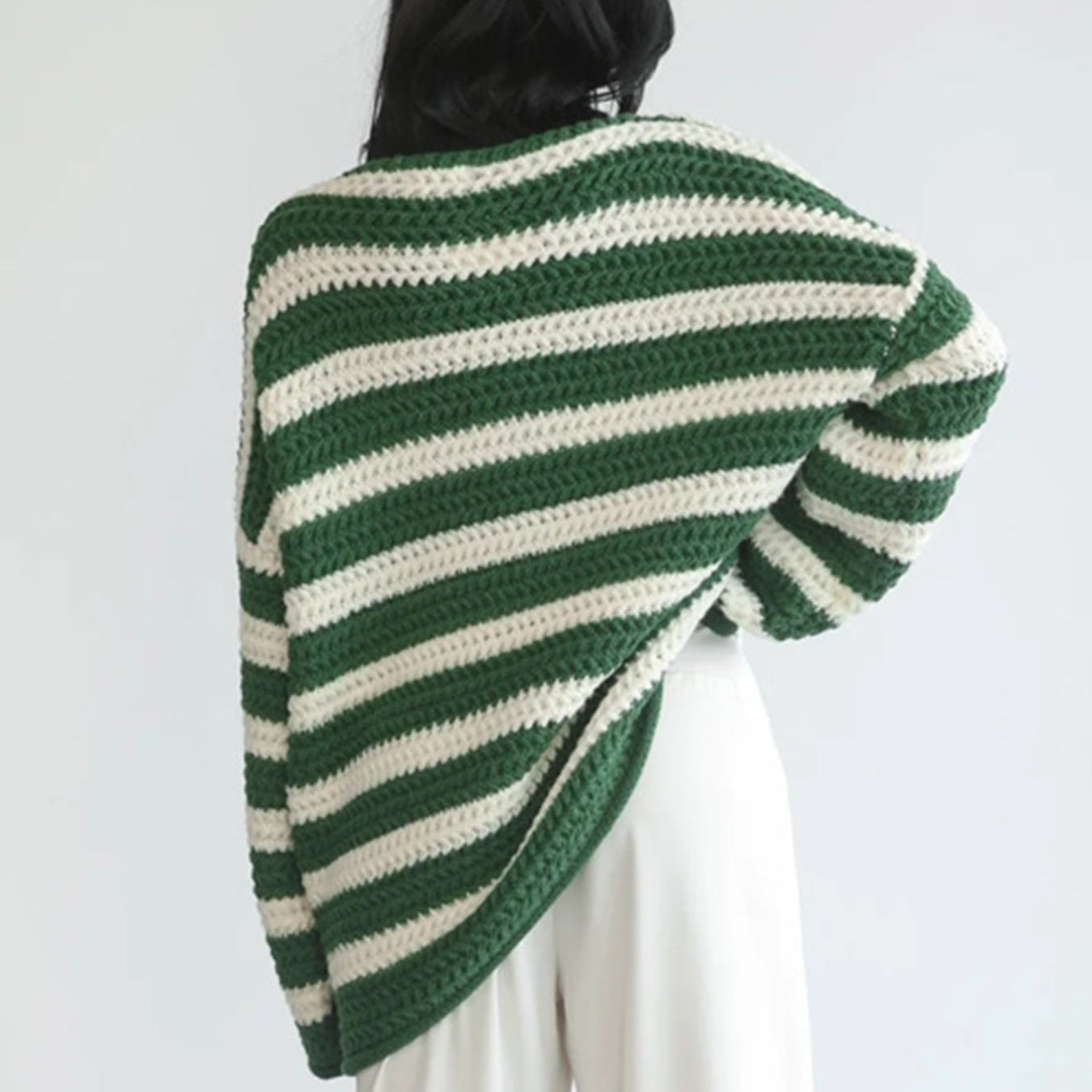 Back view of the Solange Sweater Chunky-Knit Striped in green, featuring green and white horizontal stripes, long sleeves, chunky knit texture, and an oversized relaxed silhouette. Designed by Bella Hudson.