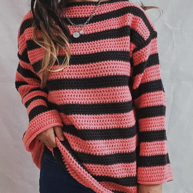 Front view of the Solange Sweater Chunky-Knit Striped in pink, featuring pink and dark horizontal stripes, a round neckline, long sleeves, chunky knit texture, and a relaxed oversized silhouette. Designed by Bella Hudson.