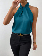 Front view of the Solenne Top Satin Halter Tie-Neck in dark blue, featuring a halter tie neckline, sleeveless design, and elegant satin finish. Designed by Bella Hudson.