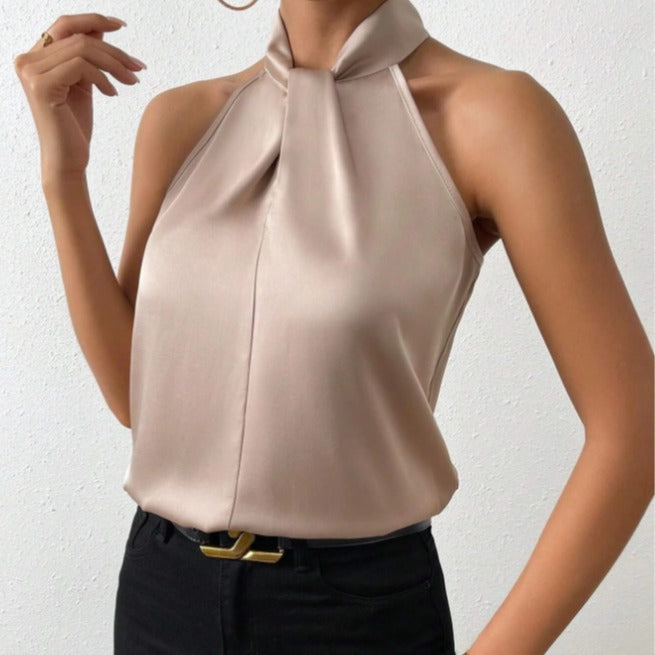 Close-up detail of the Solenne Top Satin Halter Tie-Neck in light brown, featuring the elegant halter tie neckline, soft satin fabric, and graceful draping. Designed by Bella Hudson.