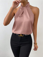 Front view of the Solenne Top Satin Halter Tie-Neck in pink, featuring a halter tie neckline, sleeveless design, and flowing satin silhouette. Designed by Bella Hudson.