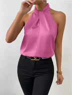 Front view of the Solenne Top Satin Halter Tie-Neck in pink, featuring a halter tie neckline, sleeveless design, lustrous satin fabric, and a relaxed elegant silhouette. Designed by Bella Hudson.