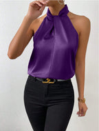 Front view of the Solenne Top Satin Halter Tie-Neck in purple, featuring a halter tie neckline, sleeveless design, silky satin fabric, and a graceful draped silhouette. Designed by Bella Hudson.