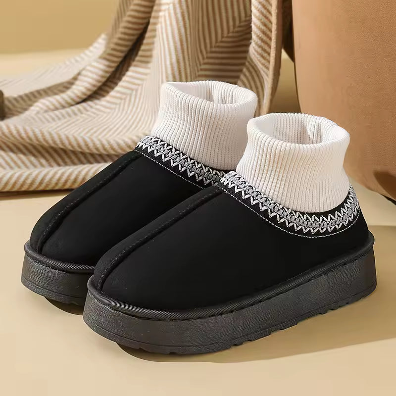 Sophie Black slip-on ankle slippers featuring a ribbed knit collar, decorative trim, and thick textured sole