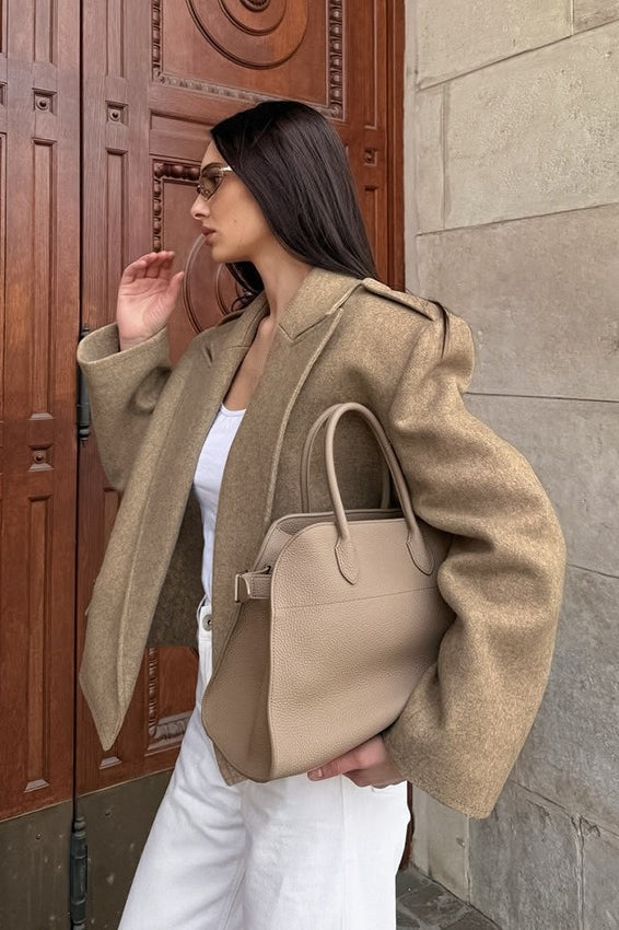 Tahlia Khaki cropped blazer worn open in a side view with a white top, white pants and a matching tote bag.