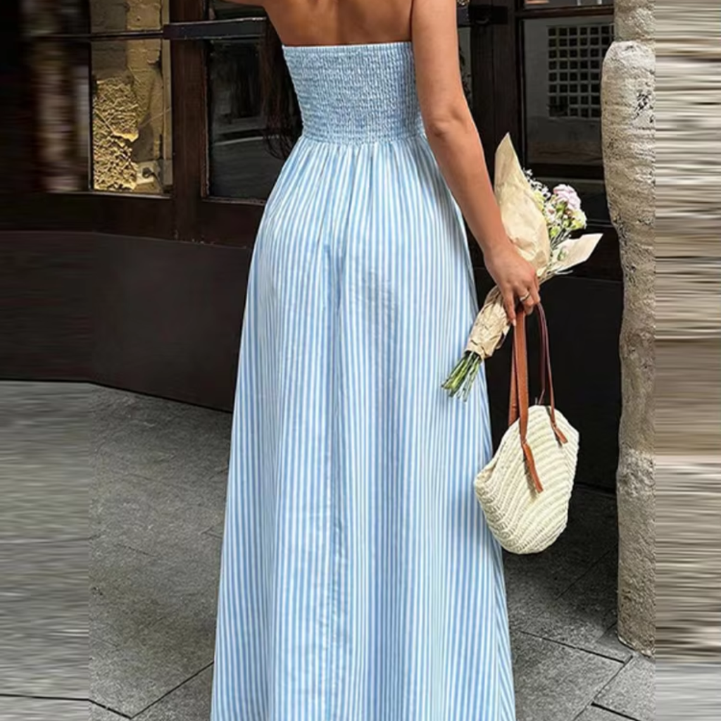 Back view of Talia Blue Striped Halter Maxi Dress featuring an open back design, halter tie closure, and flowy maxi silhouette, designed by BELLA HUDSON