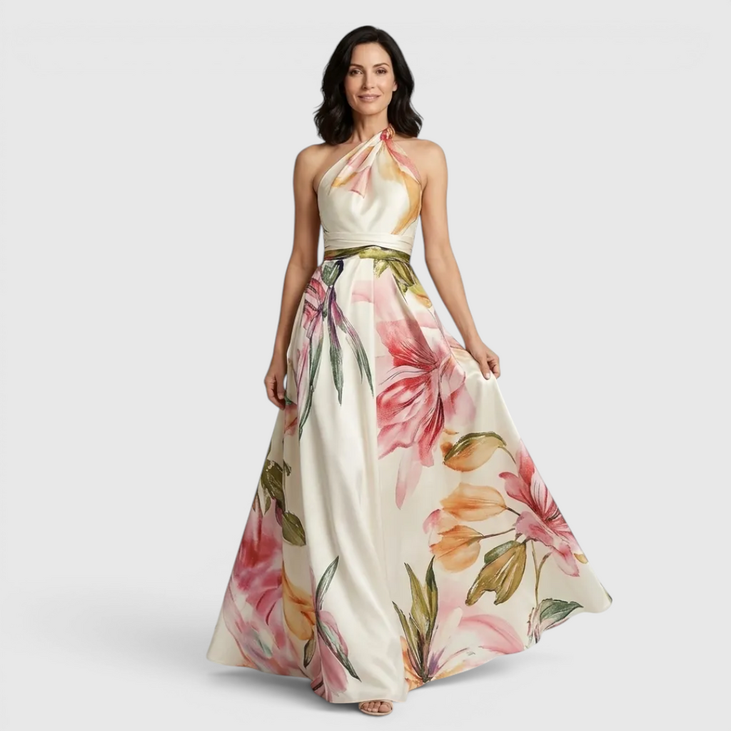 Front view of the Talia Maxi Dress Floral-Print Satin with Halter Neck in pink, featuring a halter neckline, satin finish, flowing A-line skirt, and oversized floral print. Designed by Bella Hudson.