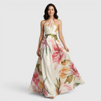 Front view of the Talia Maxi Dress Floral-Print Satin with Halter Neck in pink, featuring a halter neckline, satin finish, flowing A-line skirt, and oversized floral print. Designed by Bella Hudson.