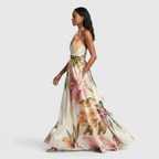 Side view of the Talia Maxi Dress Floral-Print Satin with Halter Neck in pink, showcasing the halter neckline, flowing satin skirt, and elegant oversized floral print. Designed by Bella Hudson.