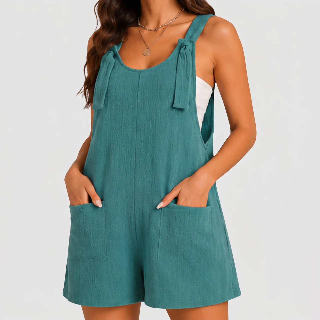 Front view of teal sleeveless short jumpsuit with side pockets by BELLA HUDSON