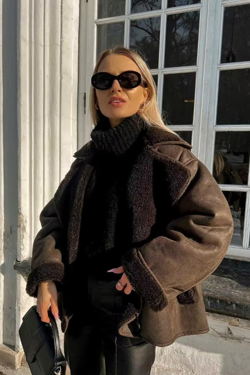 Tessa Brown faux suede jacket with a textured shearling-style collar and cuffs worn over a chunky black turtleneck.
