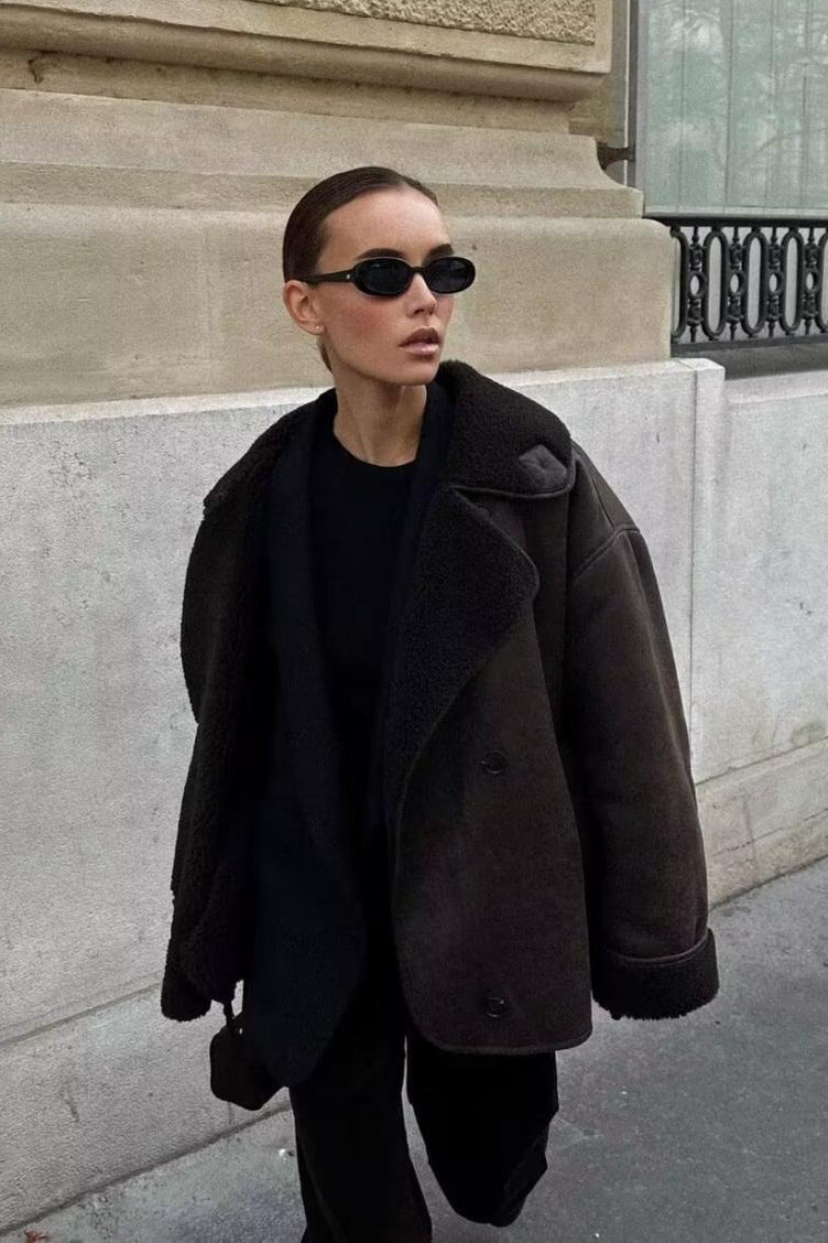 Tessa Brown faux suede jacket worn open in an all-black outfit with shearling-style lapels and cuffs.