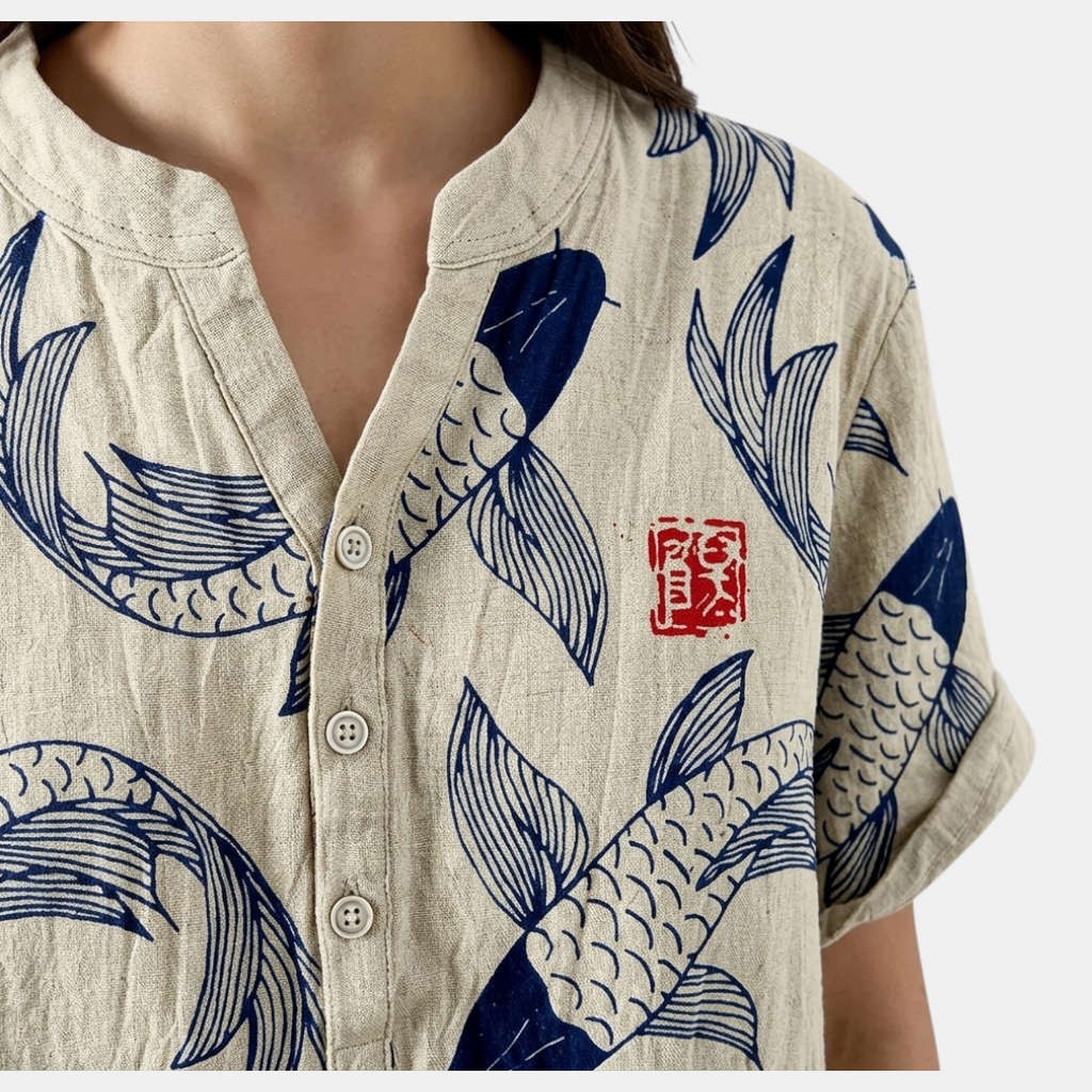 Close-up detail of the Vintage Fish-Print Linen Shirt in beige, featuring the band collar, button-front placket, and intricate fish print on textured fabric. Designed by Bella Hudson.