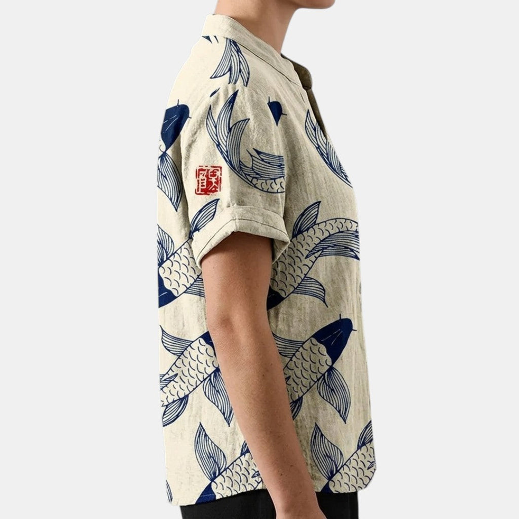 Side view of the Vintage Fish-Print Linen Shirt in beige, showcasing the relaxed fit, short sleeves, band collar, and all-over fish print. Designed by Bella Hudson.