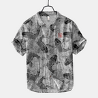 Front view of the Vintage Fish-Print Linen Shirt in black, featuring a relaxed fit, short sleeves, band collar, and an all-over fish print for casual everyday wear. Designed by Bella Hudson.