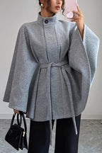 Vivian Gray belted cape coat featuring a structured stand collar, wide sleeves, adjustable waist belt, and relaxed cape-style shape