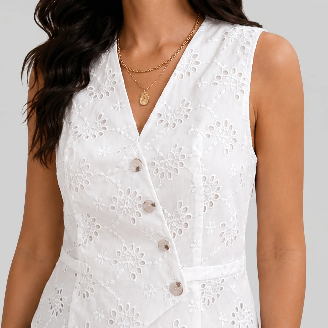 Close-up view of white eyelet button vest blouse with sleeveless tailored fit by BELLA HUDSON