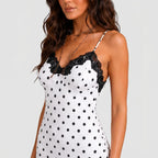 Close-up view of white polka dot maxi dress with black lace trim and spaghetti straps by BELLA HUDSON