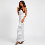 Side view of white polka dot maxi dress with black lace trim and spaghetti straps by BELLA HUDSON